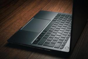 Closeup image of wood desk with modern laptop. Business and finance concept. Technology keyboard with copy space. photo