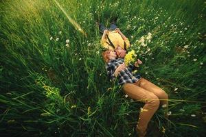 couple lying in a field of flowers. Happy couple lie in a flower. Romance, emotional and love scene. photo