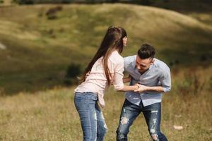 Pareja joven loca divirtiéndose emocionalmente, besándose y abrazándose al aire libre. amor y ternura, romance, familia, emociones, diversión. divirtiéndonos juntos foto