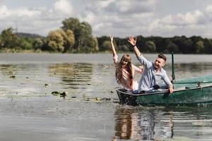 Feeling playful. Beautiful young couple enjoying romantic date while rowing a boat. Happy to have each other. photo