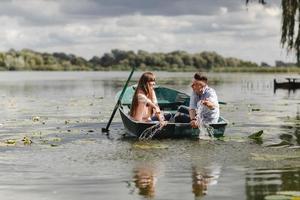 sintiéndose juguetón. hermosa pareja joven disfrutando de una cita romántica mientras rema un bote. felices de tenernos el uno al otro. foto