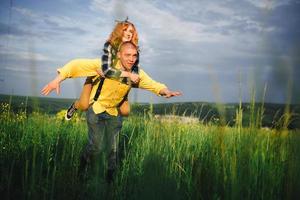 Playful happy handsome couple having while walking in woods. tourists in the mountains. Adventure in nature concept. photo