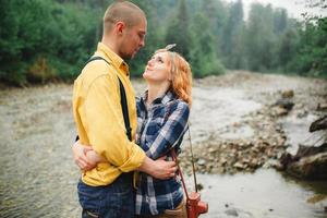 Playful happy handsome couple having while walking in woods. tourists in the mountains. Adventure in nature concept. photo