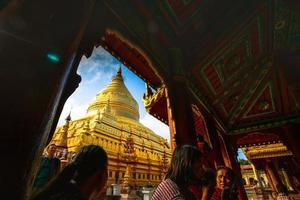 Bagan, Mandalay region, Myanmar - January 9, 2019 - Tourists visit at Shwezigon Pagoda, or Shwezigon Paya, a Buddhist temple located in Nyaung-U, a town near Bagan photo