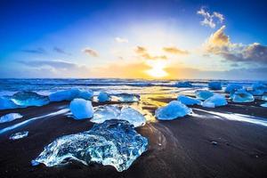 Ice rock with black sand beach at Jokulsarlon beach, or Diamond beach, in southeast Iceland photo