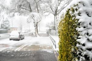 snow-covered european city, road on the street with private houses and trees photo