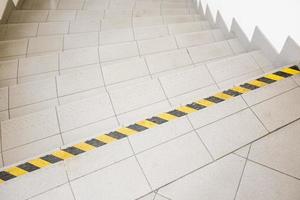 stairs with a warning sticker with yellow and black stripes photo