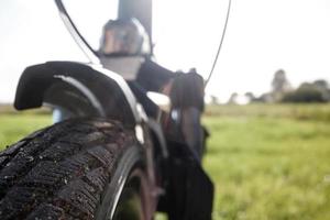 Bike tire on a bicycle wheel against the background of a field in the countryside. Close-up. photo