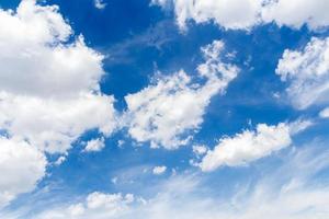 un grupo de nubes blancas reunidas en movimiento. , con un fondo de cielo azul foto