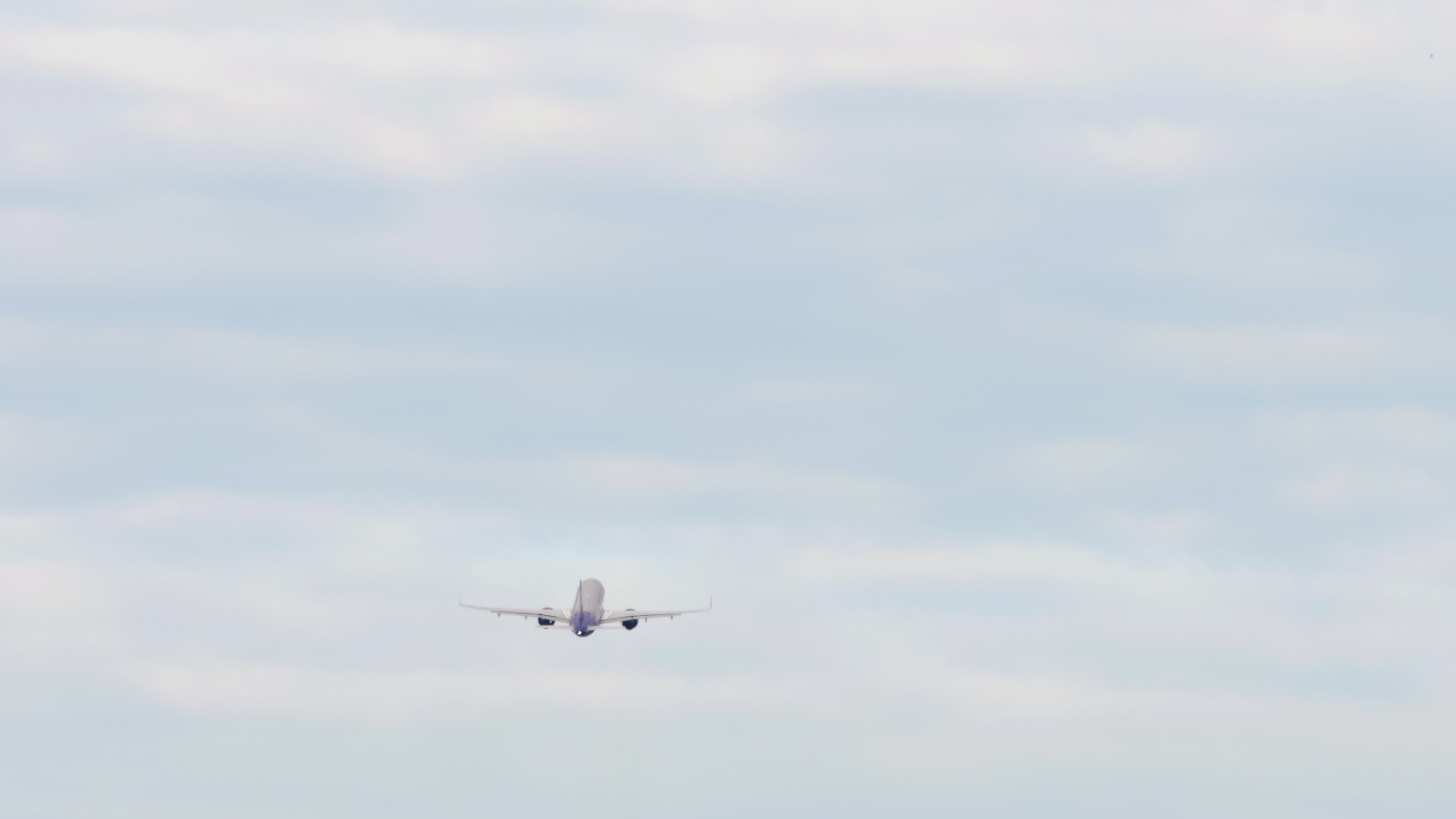 Jet plane taking off and gaining altitude in the cloudy sky in the