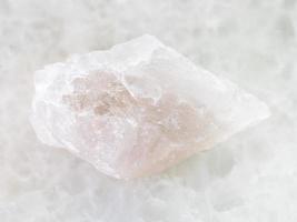 piedra de cuarzo en bruto sobre mármol blanco foto