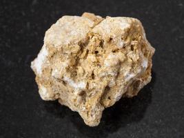 rough travertine stone on dark background photo