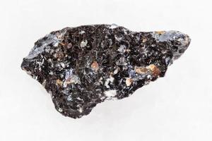 piedra de vidrio volcánico de obsidiana cruda en blanco foto