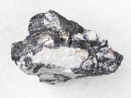 Bismuthinite vein in raw quartz stone on white photo