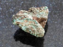 raw Malachite copper ore stone on dark photo