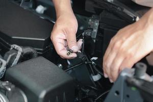 Close up hand a man plugging in for Xenon car headlights in engine room basic service concept do it yourself easily of car photo