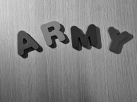 Black and white photo of the alphabet on a wooden table that says ARMY.