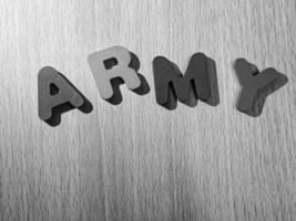 Black and white photo of the alphabet on a wooden table that says ARMY.