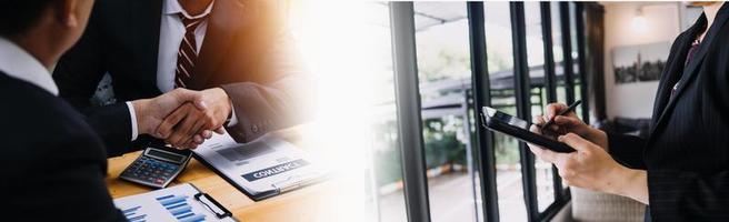 Businessman hands working with finances about cost and calculator and laptop with tablet, smartphone at office in morning light photo