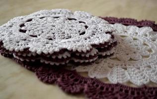 White and purple hand hooked coaster. Knitted holders for hot work photo