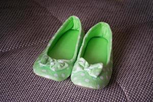 Female home green soft slippers on floor background photo