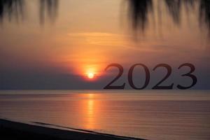 Concepto de feliz año nuevo 2023, hermoso paisaje marino de la playa con texto 2023 al amanecer en la mañana y espacio de copia, comienza una nueva vida.