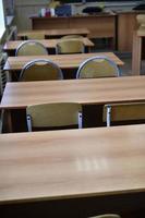 School supplies. Education concept. School desks and chairs in a student's classroom at school.t photo