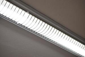 Fluorescent lamps on the whitewashed ceiling of the office space. A light lamp on the ceiling. photo