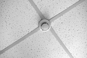 A fire sensor on the ceiling. Fire protection system in the form of a white box. photo