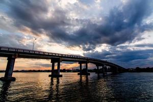 la imagen de hermosas nubes de lluvia reunidas en movimiento sobre el puente sobre el río foto