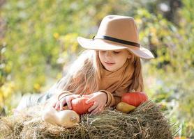 Girl in the hay with pumpkins photo