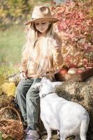 niña jugando con perro en el jardín de otoño foto