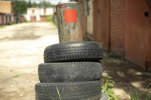 neumáticos en garajes. ruedas viejas en zona industrial. neumático de coche viejo. foto