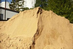 Hill of sand at construction site. Building material for foundation. Yellow sand. photo