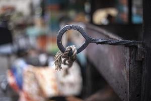 Barbecue for frying meat is in the yard. Rope on the iron structure. Place for a fire. photo