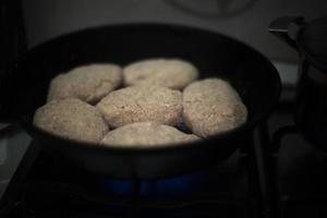 Pan-sized cutlets. Browning meat. Semi-finished product in kitchen. Cooking dinner. photo