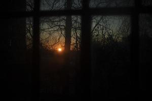 Dawn outside window. Bright sun in morning. Orange color from first rays of sun. photo