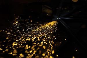 Sparks from steel. Metal sawing. Lights in dark. Work in garage. photo
