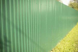 Green fence made of steel profile. High fence. Private territory. photo