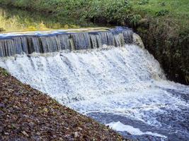 Small waterfall in a narrow fast flowing stream photo