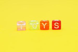 Word toys with colorful cubes of beads on yellow photo