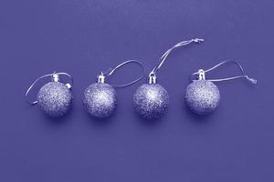 Gold Christmas balls on a blue background. Very Peri color of the year photo