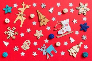 Top view of holiday toys and decorations on red Christmas background. New Year time concept photo