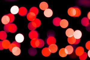 Unfocused abstract red bokeh on black background. defocused and blurred many round light photo