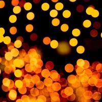 Unfocused abstract yellow bokeh on black background. defocused and blurred many round light photo