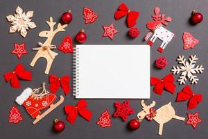 Christmas black background with holiday toys and decorations. Top view of notebook. Happy New Year concept photo