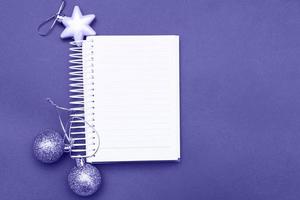 Christmas balls and toys with empty blank note sheet on a blue background photo