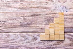 A wooden blocks cube over black wooden textured background with copy space for add word text title. Concept or conceptual Wood block stair or five steps. Cubic photo