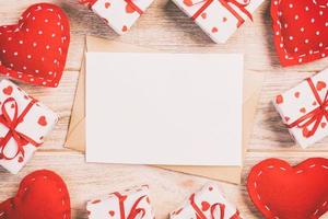 correo de sobre con corazón rojo y caja de regalo sobre fondo de madera naranja. tarjeta de san valentín, amor o concepto de saludo de boda foto