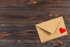 love letter envelope with red heart on wooden background. copy space photo